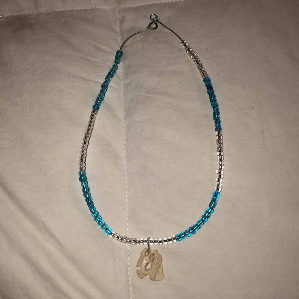 A blue and clear shell necklace on necklace wire.